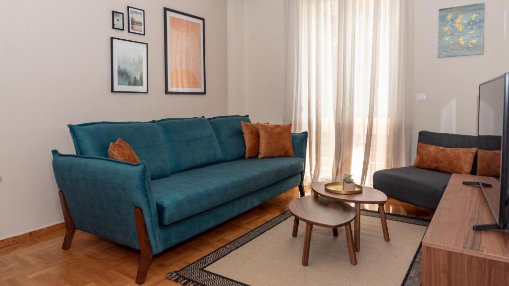 salon z niebieską kanapą i krzesłem w obiekcie Αριστοτέλους Comfy Apt. w Salonikach
