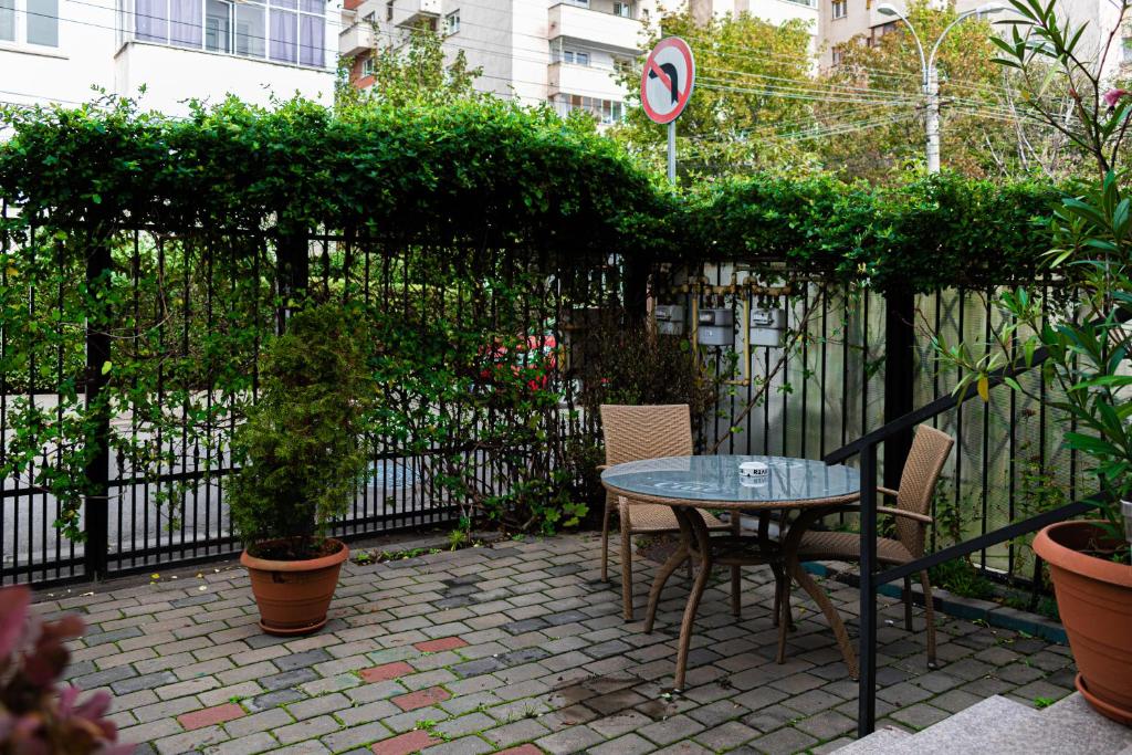 クルジュ・ナポカにあるLucas 38 Apartmentsのパティオ(テーブル、椅子、フェンス付)
