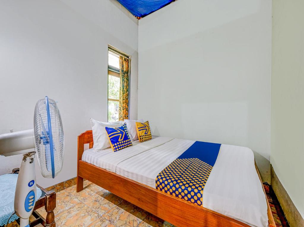 um quarto com uma cama e uma janela em OYO Homes 90987 Desa Wisata Gabugan Syariah em Balong