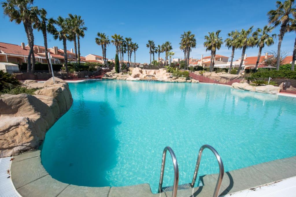 duży basen z palmami w ośrodku w obiekcie Holiday beach Gran Alacant w mieście Santa Pola