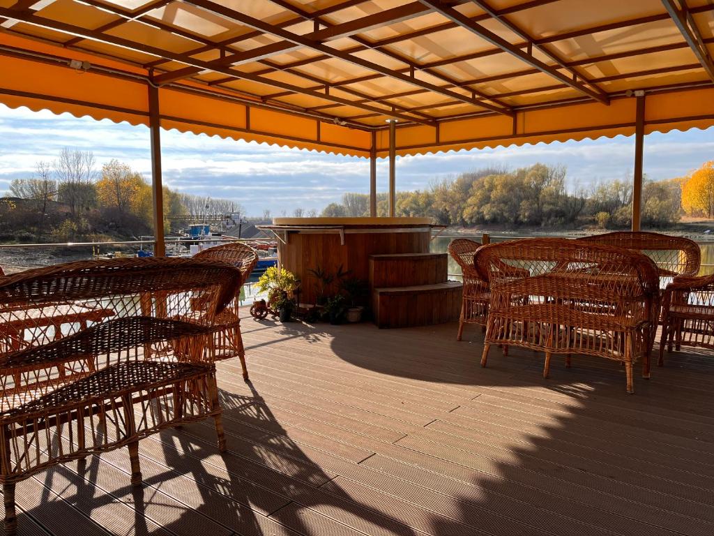 a wooden deck with chairs and tables and a view of a river at Tiena Hotel Plutitor 