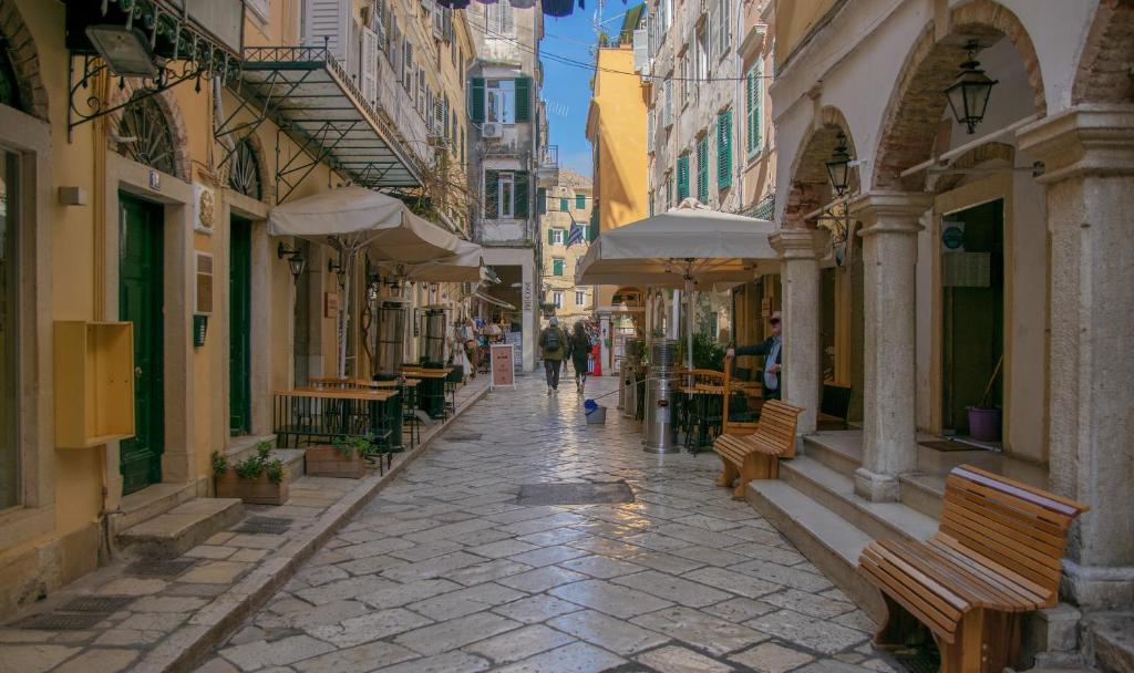 a street in a city with benches and buildings at Corfu Old Town Gregory in Corfu Town