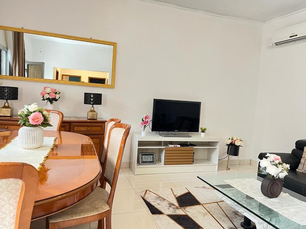 a living room with a table and a tv at Appartement meublé haut standing Bonamoussadi (Kotto) in Douala