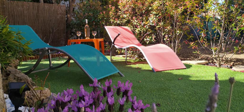 two chairs and a slide in a yard with purple flowers at LA CASA in Cagnes-sur-Mer