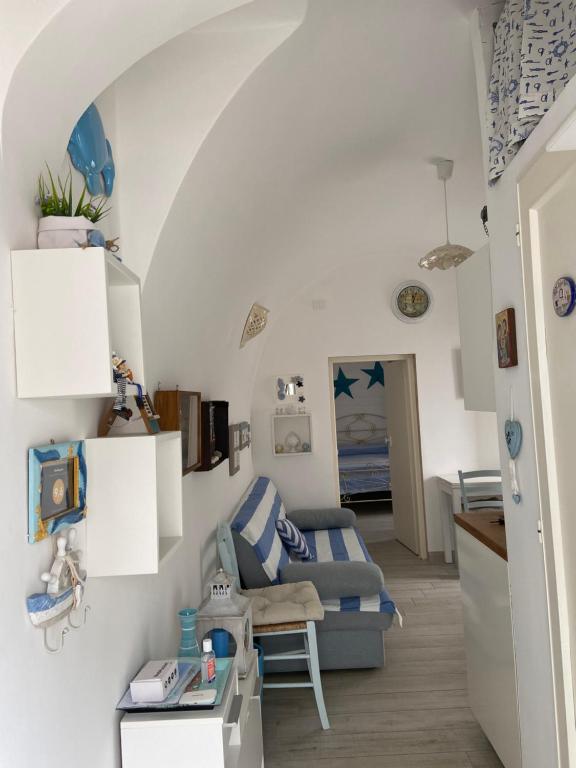 uma sala de estar com um sofá e uma mesa em Casetta Azzurra em Monopoli