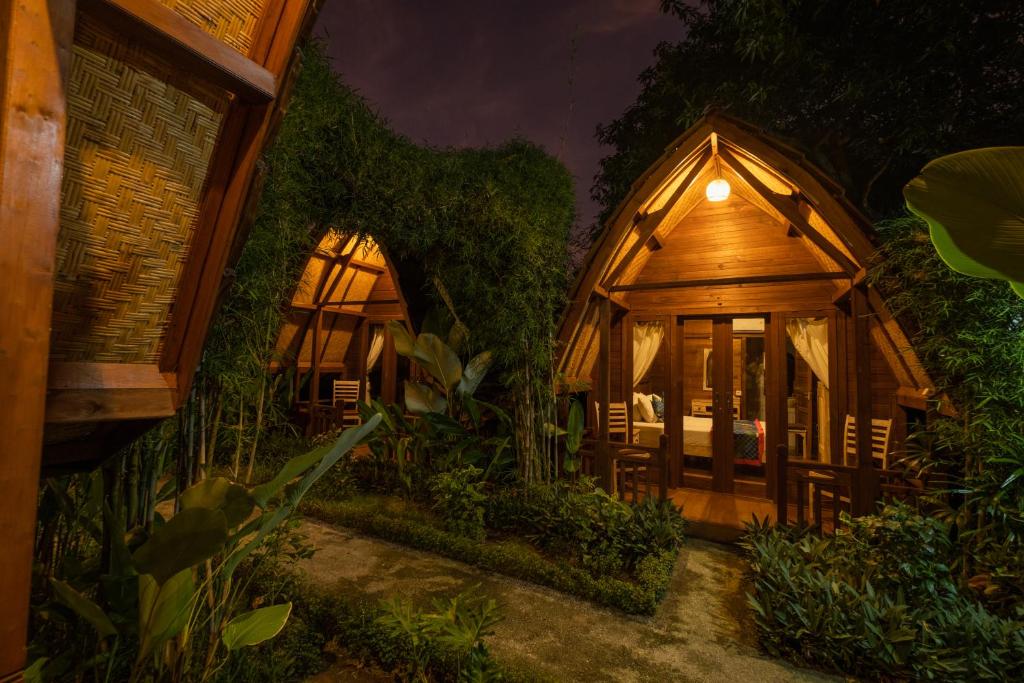 ein großes Holzhaus mit einem Bett darin in der Unterkunft Kubu Kak Dudung Villas in Jimbaran