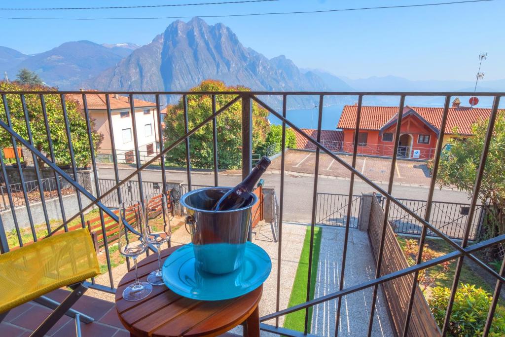 a cup on a table on a balcony with a view at Happy Guest Apartments - Lake & Green Oasis in Riva di Solto