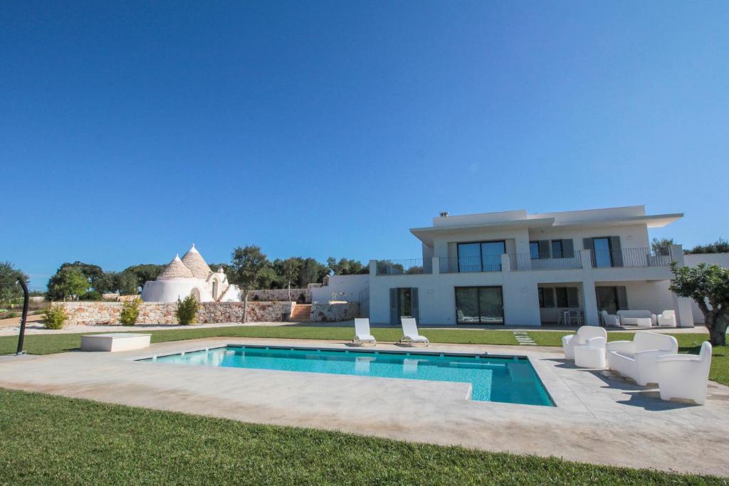 a villa with a swimming pool and lawn at white moon holiday home in Ostuni