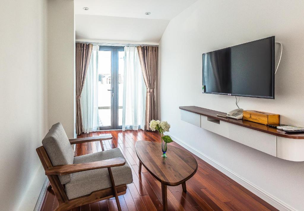 salon z telewizorem, krzesłem i stołem w obiekcie Ngan Ha 2 Apartments w Ho Chi Minh