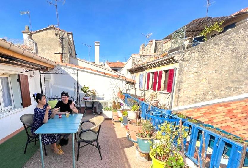 Dos mujeres sentadas en una mesa en un balcón en Loft Apartment , La Terrasse Centre Ville d'Arles,, en Arles