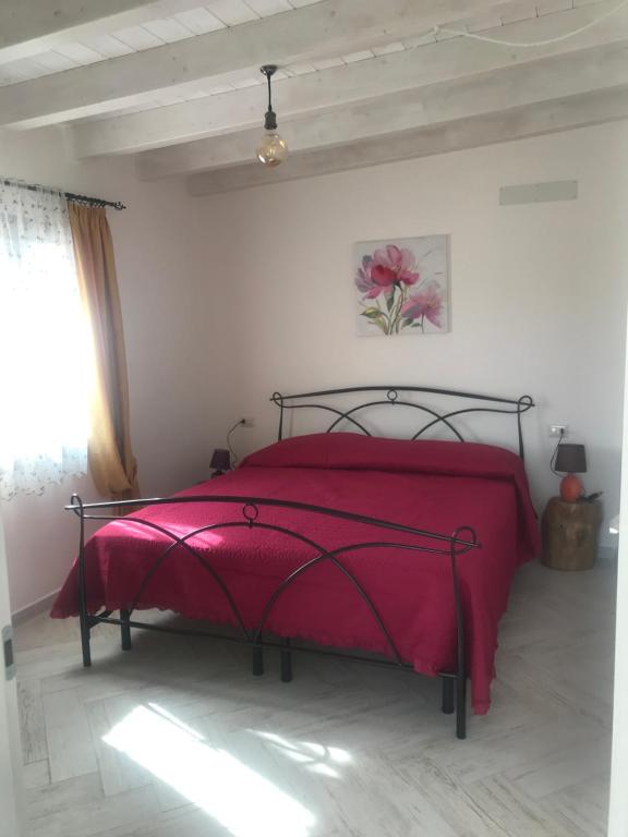 a bedroom with a bed with a red blanket at Domo Baronia in Orosei