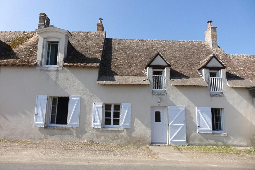 an old house with white windows and a roof at La Maison de Saint-Dyé in Saint-Dyé-sur-Loire