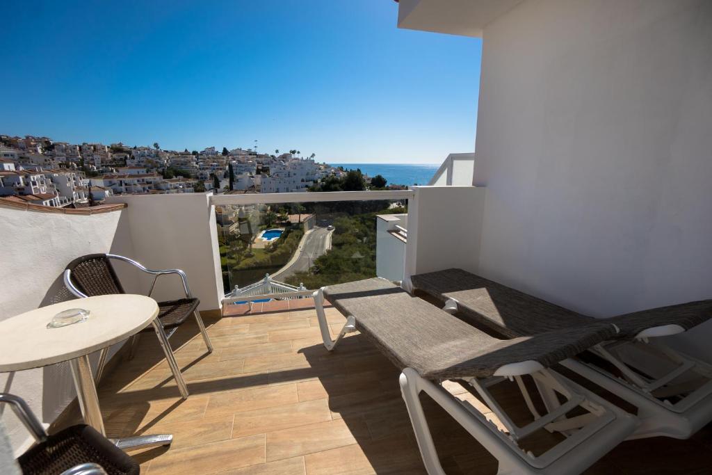 a balcony with a table and chairs and a view at Hostal Casa Mercedes in Nerja