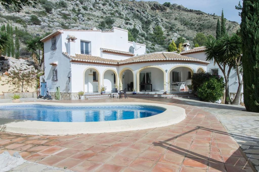 a villa with a swimming pool in front of a house at Spacious 3-bedroom villa with private pool in Benigembla, Spain. in Murla