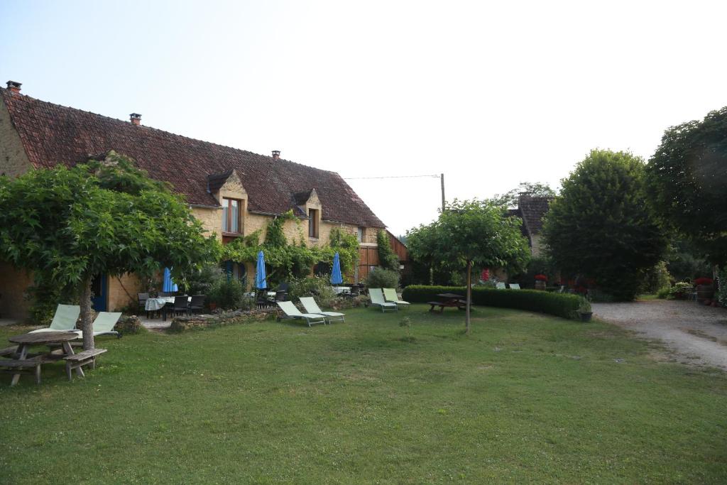 a yard with a group of chairs and a house at Papillon in Sainte-Mondane