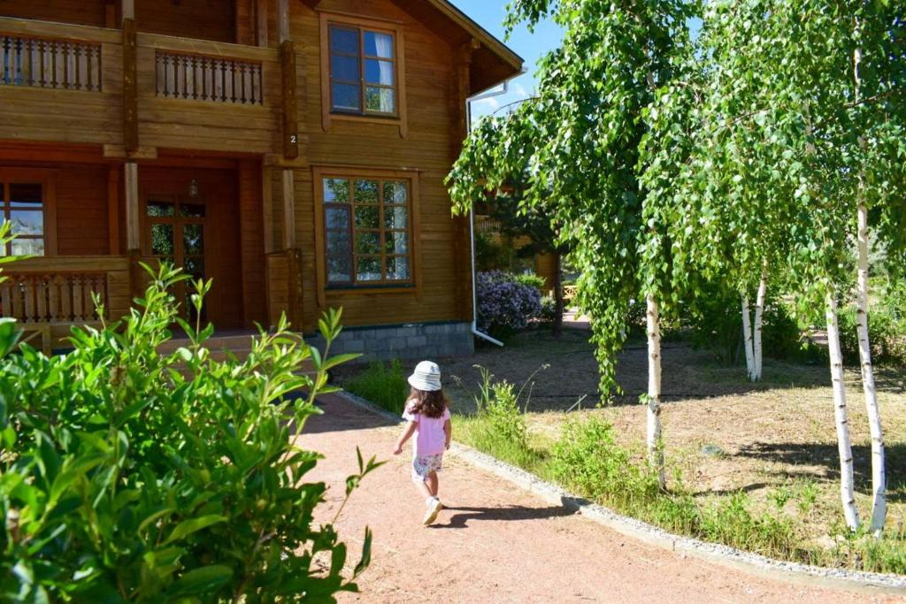 Tamga的住宿－Family club Royal-apricot，一个小女孩在房子前面的泥土路上走