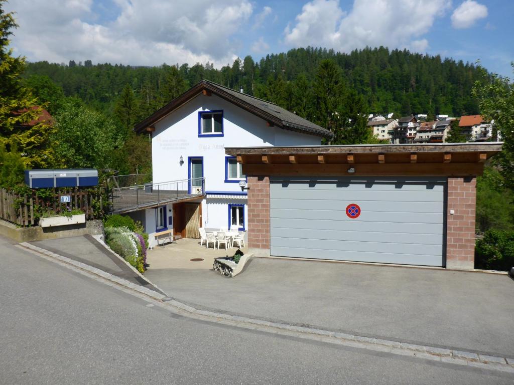 a white garage with a red number on it at Nolla Apartment in Thusis