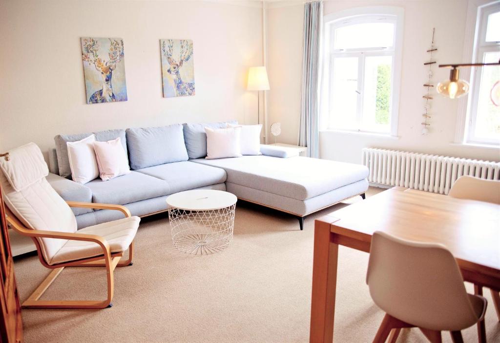 a living room with a couch and a table at Gut Kattenhöhlen in Scharbeutz