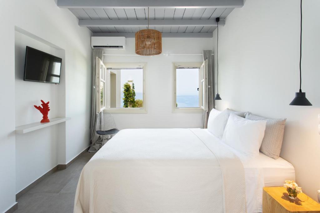 una camera con un letto bianco e due finestre di Villa Itis - Elegant Ground Floor Suite with Terrace & Great View a Neapolis