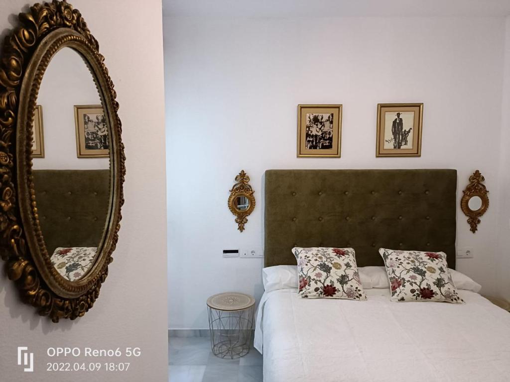 ein Schlafzimmer mit einem großen Spiegel und einem Bett in der Unterkunft Apartamento Barrio Santa Cruz, centro Sevilla in Sevilla