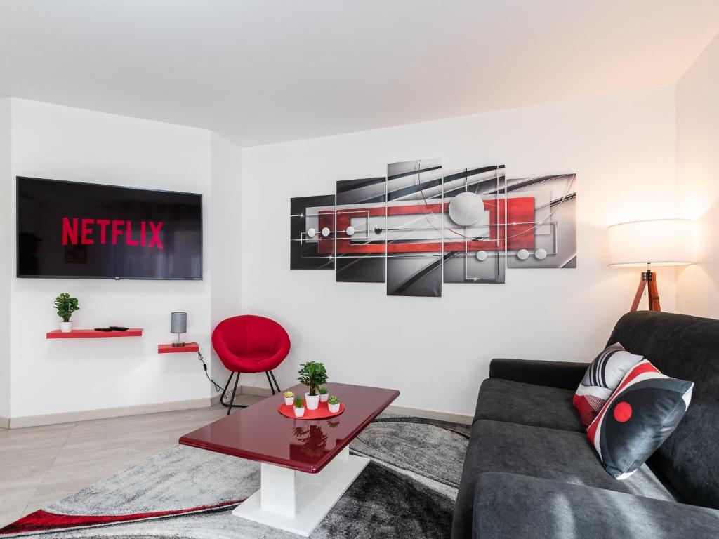 維勒班的住宿－LE STELLA - HYPERCENTRE GARAGE GRATUIT WiFi NETFLIX AMAZON PRIME PROCHE PARC TETE D'OR，带沙发和红色椅子的客厅