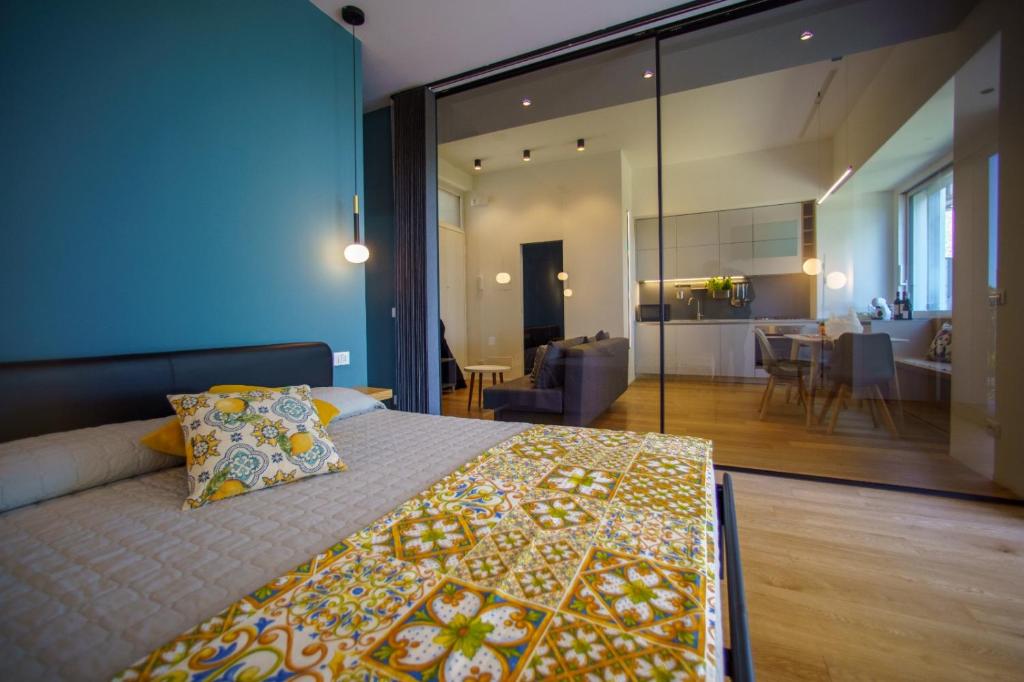 a bedroom with a large bed and a living room at Domus Aurea Luxury Apartment Cefalù in Cefalù