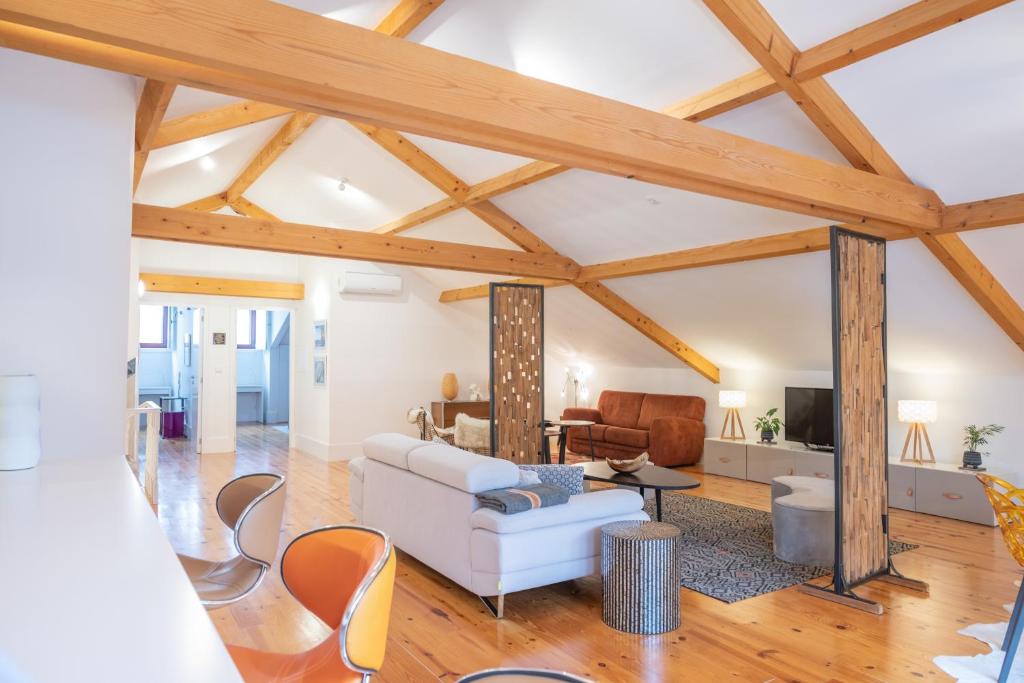 uma sala de estar com um sofá branco e tectos em madeira em Tomas Loft no Porto