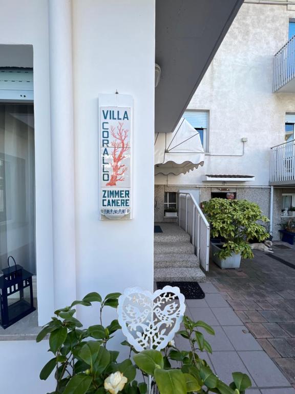 a white building with a sign on the side of it at Villa Corallo in Grado