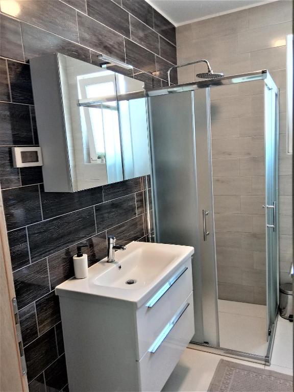 łazienka z umywalką i prysznicem w obiekcie Apartment Ivetka w Rabie