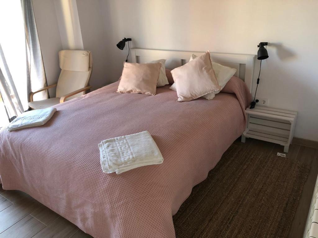 ein Schlafzimmer mit einem großen Bett mit rosa Bettwäsche und Kissen in der Unterkunft El Rincon de Cabello in Sierra