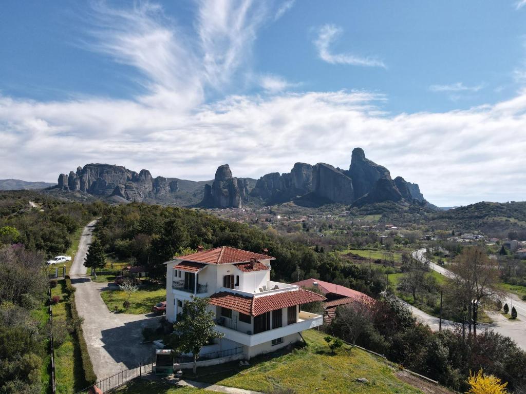 una casa en las montañas con rocas en el fondo en NATURE GUEST HOUSE KASTRAKI, en Kastraki