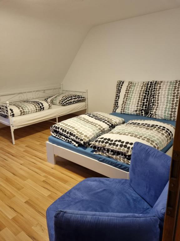 - 2 lits dans une chambre avec une chaise et un canapé dans l'établissement KM3 Apartment, à Triberg