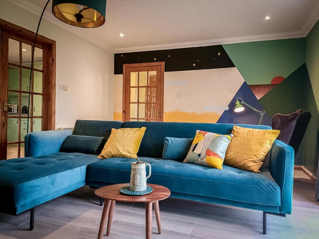 a blue couch in a living room with a table at Aite-Sithiel in Kingsburgh