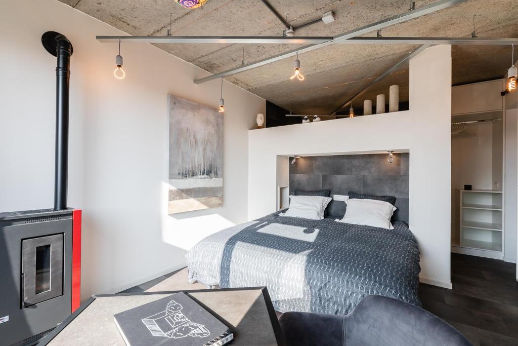 a bedroom with a bed and a fireplace at Le Garage in Theux