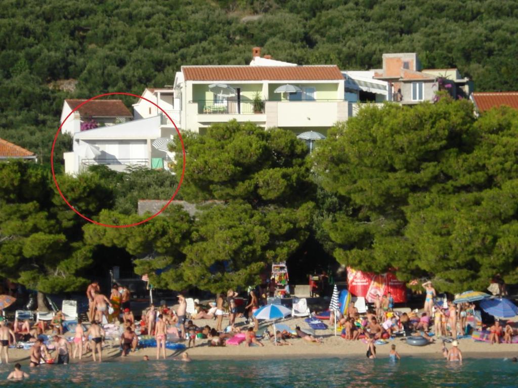a group of people on a beach near the water at Apartments Ivandić in Tučepi