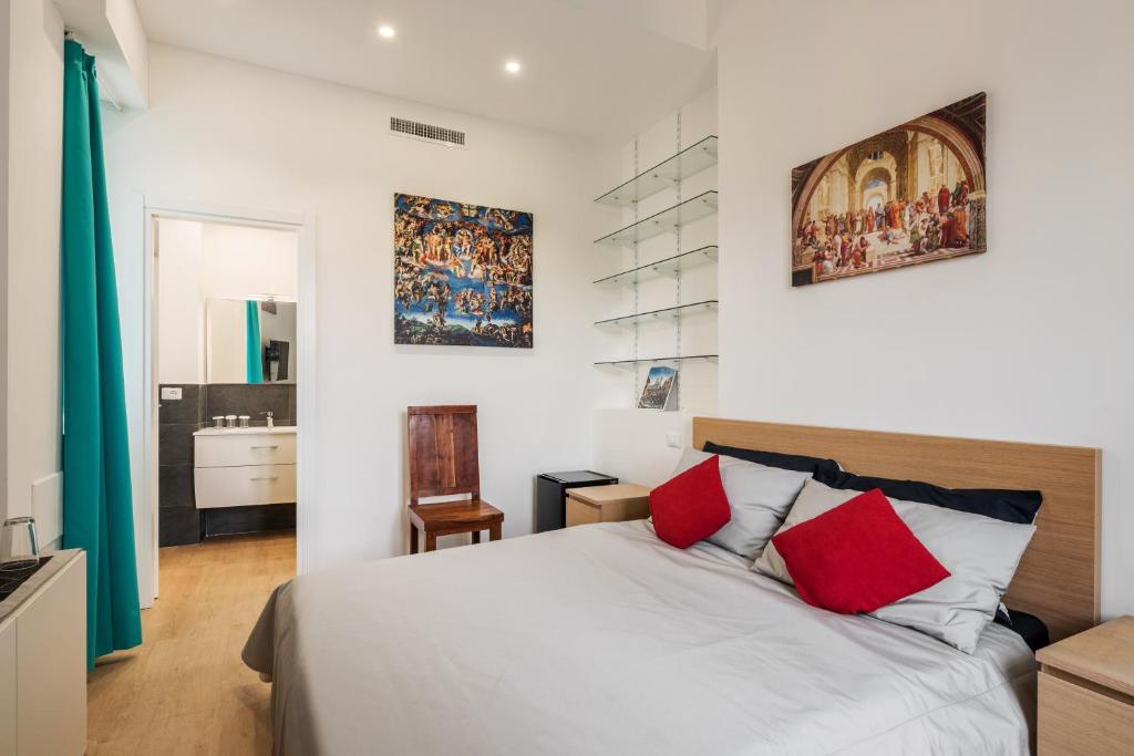 um quarto com uma cama com almofadas vermelhas e uma casa de banho em Cappella Sistina Suite em Roma