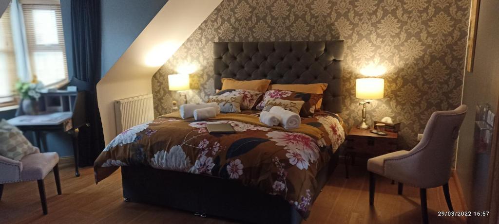 a bedroom with a large bed and two chairs at Outlander Boutique B&B Super King in Cruden Bay
