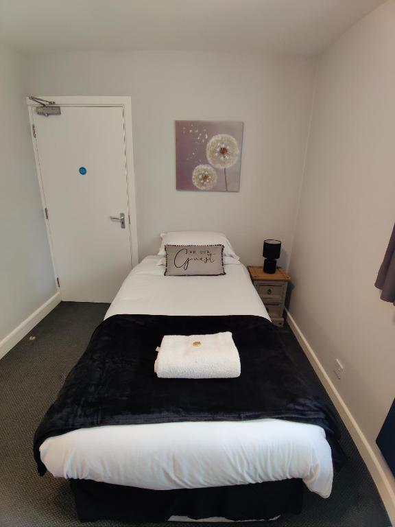 a bedroom with a bed with a black and white blanket at Woolpack Inn in Chichester