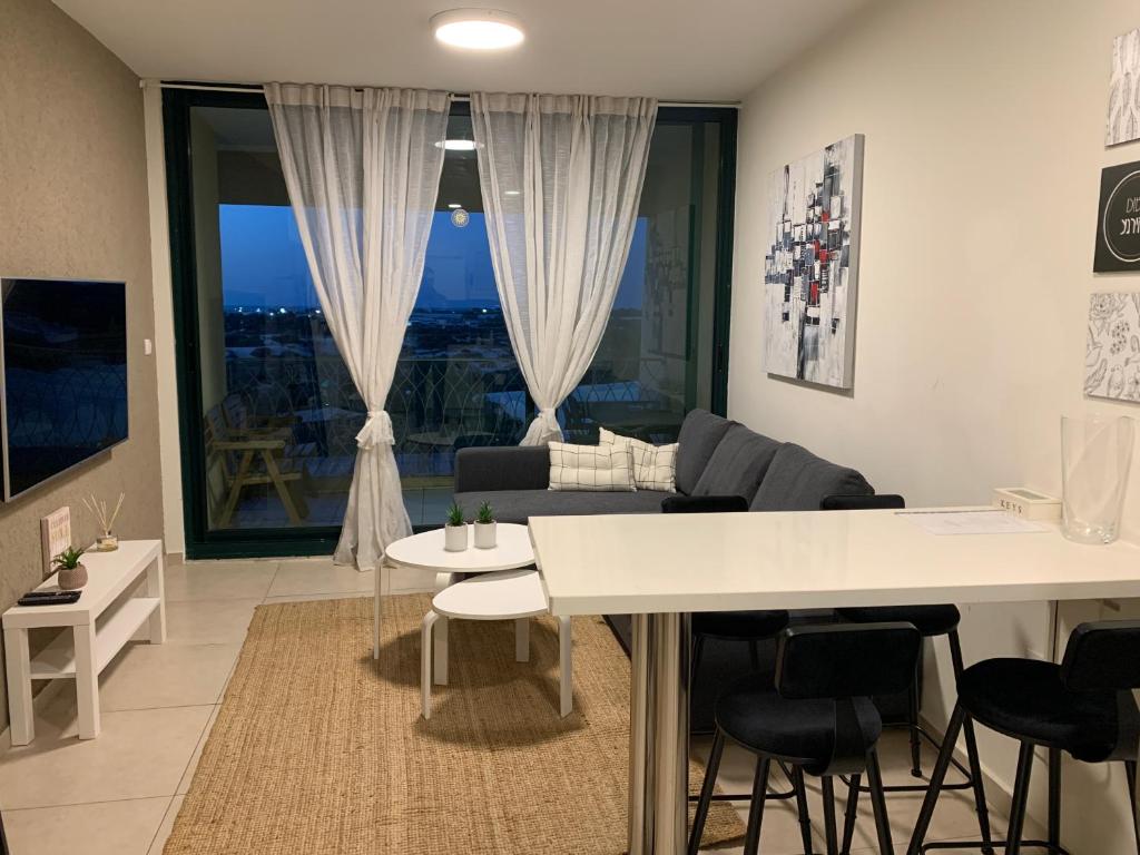 een woonkamer met een witte tafel en een bank bij Caesarea Magic in Caesarea