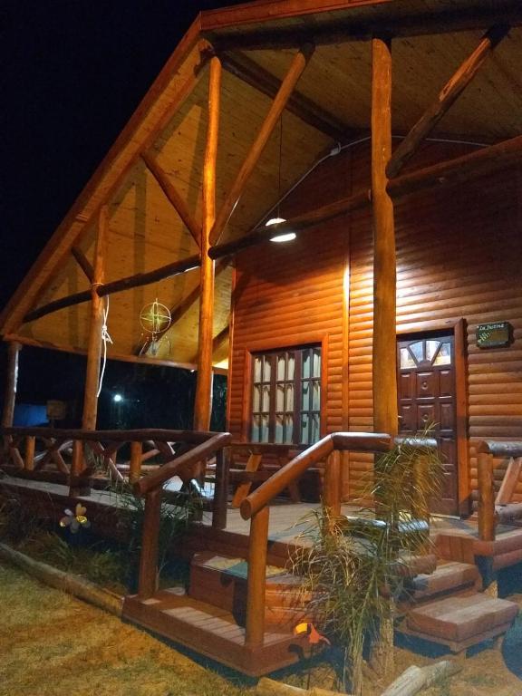a log cabin with a porch at night at Cabaña La Justina in San José