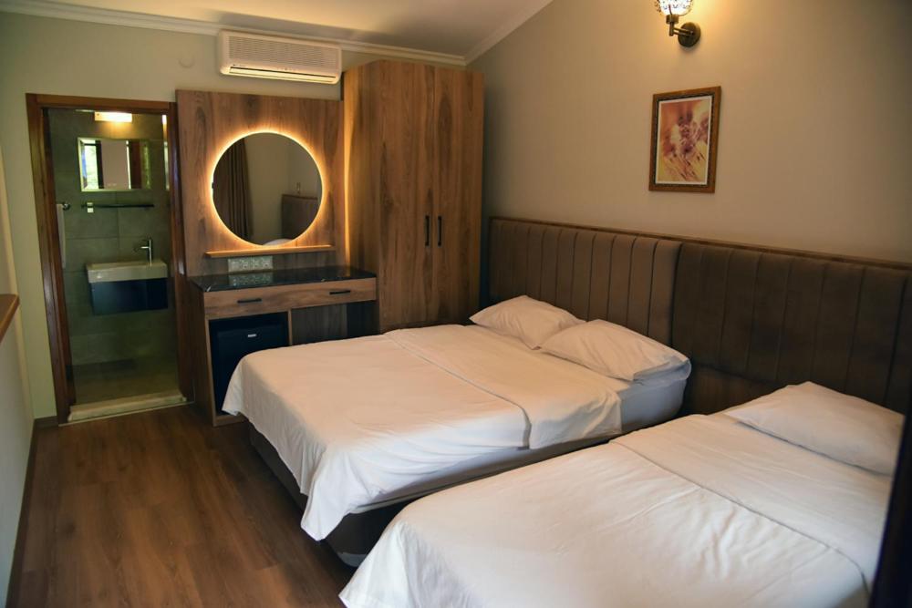 a hotel room with two beds and a mirror at Fener Motel in Şile