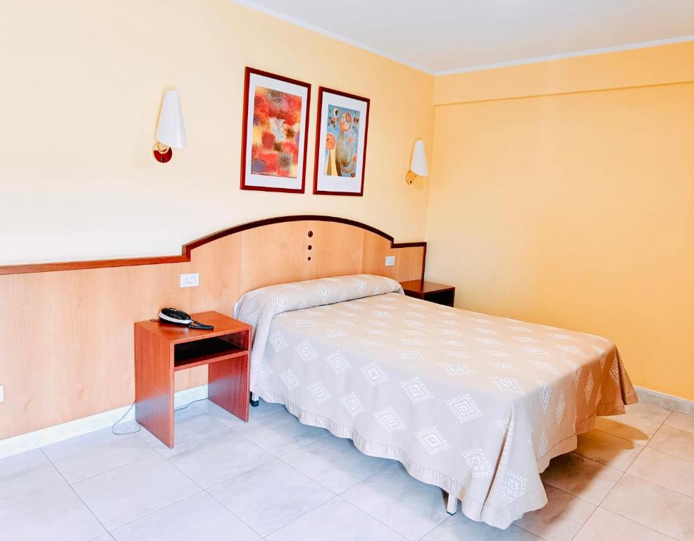 a hotel room with a bed and a table at Hotel Alameda in Villaviciosa