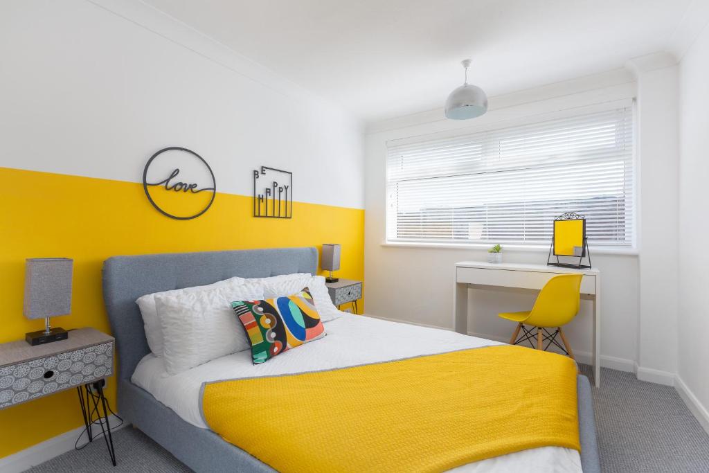 um quarto amarelo e branco com uma cama e uma secretária em Avella Suites em Lytham St Annes