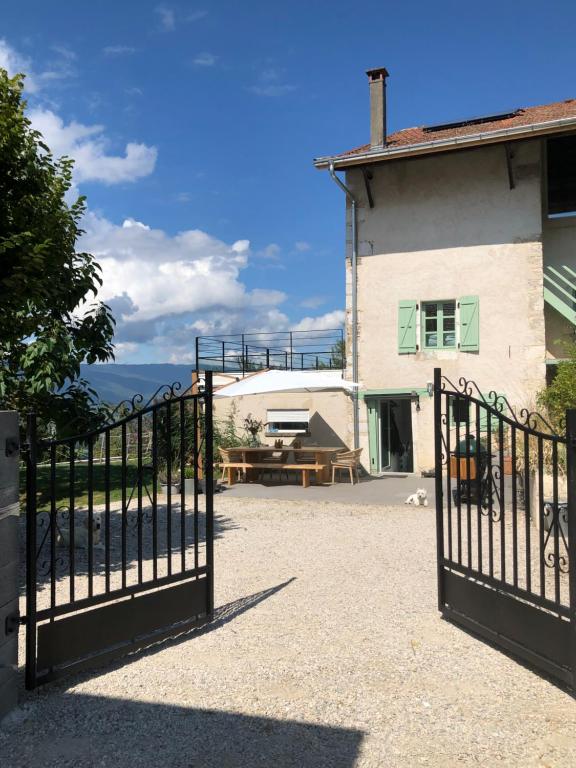 a gate in front of a house with a building at Le Paradis des Gen(t)s in Seyssel