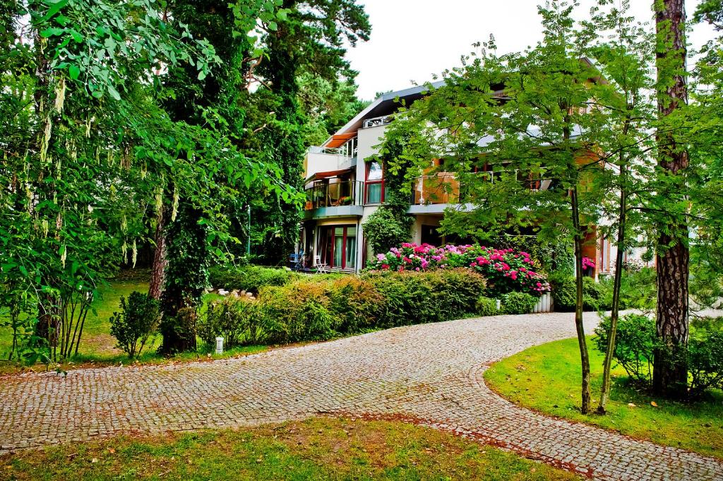 尤拉塔的住宿－Zielona Przystań BlueApart Jurata，前面有车道的大房子