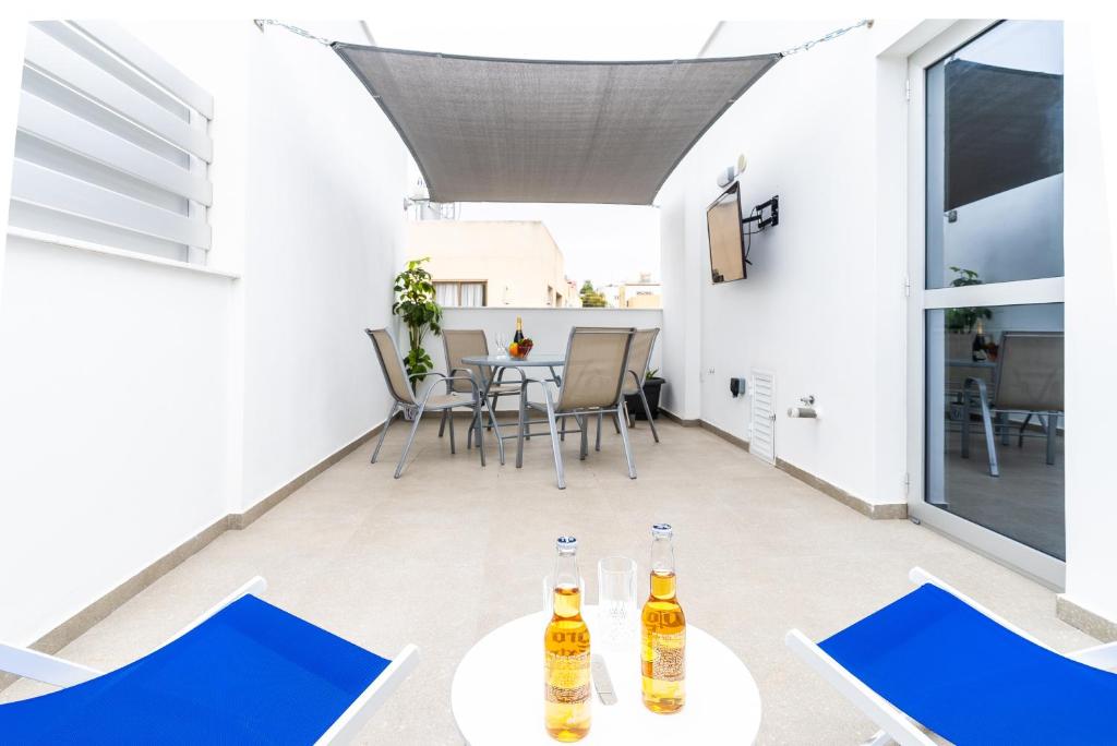 a patio with two tables and chairs with drinks on it at Spiros Luxury Apartments in Ayia Napa