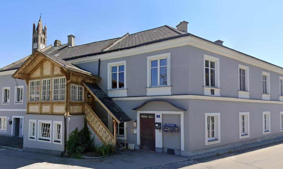 a large white house with a wooden roof at IMBACH KLOSTERHOF -Ferienapartments im Herzen der Wachau in Imbach