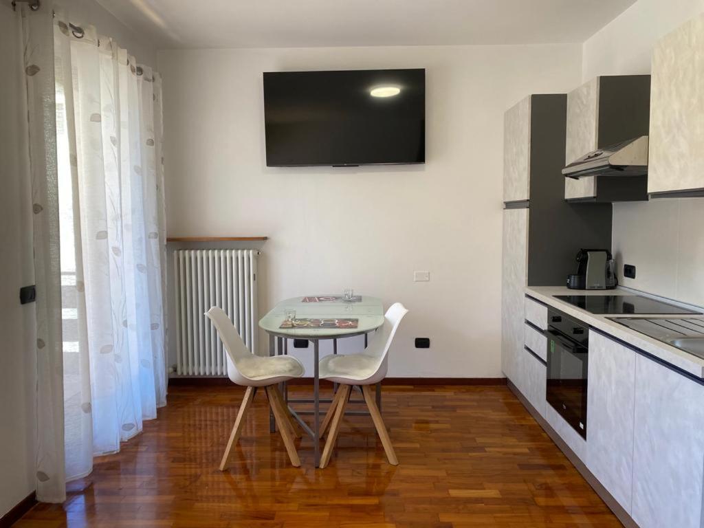 kuchnia ze stołem i 2 krzesłami w pokoju w obiekcie Appartamento Aurelia w mieście Molina di Ledro