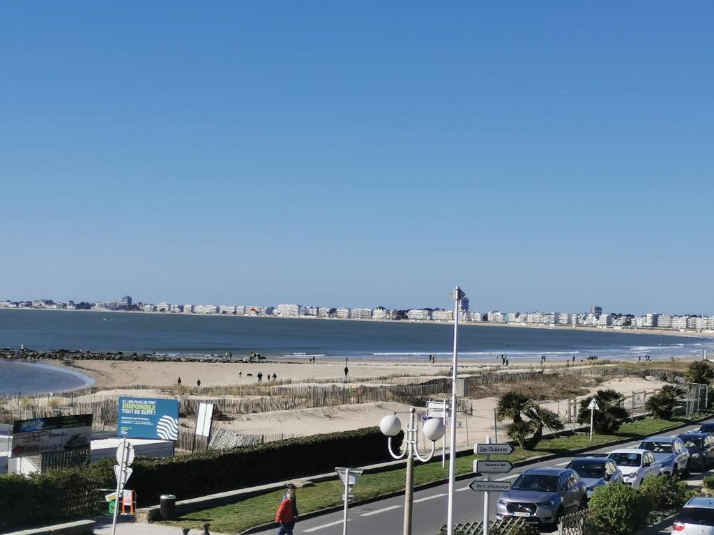 un parking avec une plage et une route avec des voitures dans l'établissement Studio confortable, face mer, proches commerces, à Pornichet