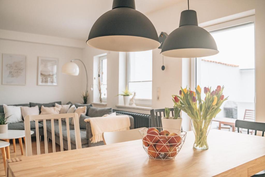 eine Küche und ein Wohnzimmer mit einem Tisch und 2 Leuchten in der Unterkunft HYGG INN Ferienhaus in Heiligendamm